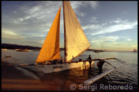 Los visitantes de la isla alquilan estas embarcaciones para ver la puesta de sol desde el mar. Barca para la práctica del sailing.  White beach. Boracay.