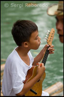 Un niño canta en el margen del río Loboc a la llegada de los turistas mientras estos realizan un trayecto en barca. Loboc. Bohol.