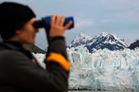 Juneau, Alaska, USA. Crew with binoculars on cruise ship Safari Endeavour at the Margerie Glacier and Mount Fairweather in Glacier Bay National Park Alaska USA. Tarr inlet in Glacier Bay National Park. Margerie Glacier is a 21-mile-long (34 km) tide water glacier in Glacier Bay in Alaska and is part of the Glacier Bay National Park and Preserve. It begins on the south slope of Mount Root, at the Alaska-Canada border in the Fairweather Range, and flows southeast and northeast to Tarr Inlet. It was named for the famed French geographer and geologist Emmanuel de Margerie (1862–1953), who visited the Glacier Bay in 1913.