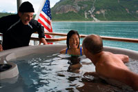 Juneau, Alaska, USA. Passengers enjoying hot tub on cruise ship Safari Endeavour anchgored Scenery Cove Thomas Bay Tongass National Forest Alaska USA.  Big trees, big birds, big fish, big bears, immense peaks wrapped in great glaciers that break off into bays where great whales spout: This is Southeast Alaska, the state's panhandle. It separates northern British Columbia from the open Pacific with a chain of misty, fjord-footed mountains and a jigsaw puzzle of more than a thousand islands.