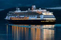 Juneau, Alaska, USA. Zaandam, sailing near the South Franklin dock, at night, Juneau, Alaska. Designed to carry fewer guests while providing more space for maximum comfort, ms Zaandam is a prize in the mid-size ship category. Offering spacious public areas and plush accommodations, many staterooms have private verandahs.