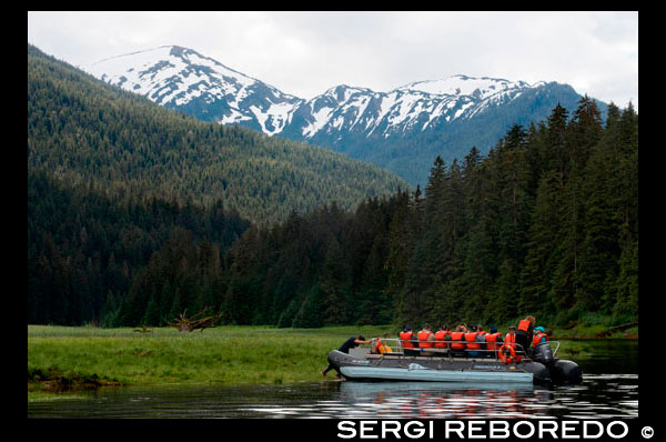 Safari Endeavour cruise passengers in an inflatable boat in Scenery Cove, Thomas Bay, Petersburg, Southeast Alaska. Thomas Bay is located in southeast Alaska. It lies northeast of Petersburg, Alaska and the Baird Glacier drains into the bay. Thomas Bay is also known as "The Bay of Death" due to a massive landslide in 1750. It also has gained the name of "Devil's Country" when in 1900 several people claimed to have seen devil creatures in the area. Thomas Bay is known for being rich in gold and quartz. The wildlife has moose, brown bears, black bears, squirrels, wolves, rabbits, and other common Alaskan creatures. The land has been used for logging. Charlie claimed to have arrived in Thomas Bay, but couldn't find the half-moon shaped lake. Instead he spent some time off an 'S' shaped lake (actually called Ess Lake). He claimed that the surrounding area seemed oddly void of life. There were no squirrels, no birds, etc. Wanting to get his bearings after he found his large chunk of quartz, he climbed to the top of a ridge. From there he could spot Frederick Sound, Cape of the Straight Light, the point of Vanderput Spit (Point Vanderput), and Sukhoi Island from the mouth of Wrangell Narrows. Behind the ridge, Charlie finally spotted the half-moon shaped lake, which is where the Patterson Glacier turns into a lake that turns into Patterson River.
