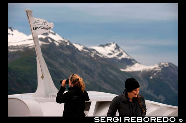 Crew and passengers with binoculars on cruise ship Safari Endeavour at the Margerie Glacier and Mount Fairweather in Glacier Bay National Park Alaska USA. Tarr inlet in Glacier Bay National Park. Margerie Glacier is a 21-mile-long (34 km) tide water glacier in Glacier Bay in Alaska and is part of the Glacier Bay National Park and Preserve. It begins on the south slope of Mount Root, at the Alaska-Canada border in the Fairweather Range, and flows southeast and northeast to Tarr Inlet. It was named for the famed French geographer and geologist Emmanuel de Margerie (1862–1953), who visited the Glacier Bay in 1913. It is an integral part of the Glacier Bay, which was declared a National Monument on February 26, 1925, a National Park and Wild Life Preserve on December 2, 1980, a UNESCO declared World Biosphere Reserve in 1986 and a World Heritage Site in 1992. While most of the tidewater and terrestrial glaciers in the Park are stated to be thinning and receding over the last several decades, Margerie Glacier is said to be stable and Johns Hopkins Glacier is stated to be advancing, on the eastern face of the Fairweather Range. 
