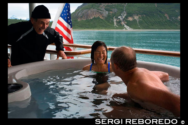 Passengers enjoying hot tub on cruise ship Safari Endeavour anchgored Scenery Cove Thomas Bay Tongass National Forest Alaska USA.  Big trees, big birds, big fish, big bears, immense peaks wrapped in great glaciers that break off into bays where great whales spout: This is Southeast Alaska, the state's panhandle. It separates northern British Columbia from the open Pacific with a chain of misty, fjord-footed mountains and a jigsaw puzzle of more than a thousand islands. Known as the Alexander Archipelago, the islands help explain how a region less than 500 miles (800 kilometers) long can have 18,000 miles (29,000 kilometers) of shoreline (almost all wild, whereas the longest stretch of undeveloped coast in the contiguous states is 30 miles (50 kilometers), more than 10,000 estuaries, and 13,750 river miles (22,130 kilometers) that host oceangoing fish. About 5 percent of Southeast Alaska is owned by native tribes or the state. Another 12.5 percent makes up Glacier Bay National Park and Preserve. All the rest—16.8 million acres (6.8 million hectares)—is the Tongass National Forest.
