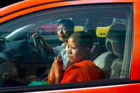 Bangkok. Young buddhist monk inside a taxi. The Sangha World in Thailand consists of about 200,000 monks and 85,000 novices at most times of the year. However, these numbers increase during the Buddhist ‘lent’ to 300,000 and 100,000 novices. Young boys may become novices at any age, but a man cannot become a monk until he reaches the age of twenty. He can then remain a monk for as long as he wishes, even for just one day. Three months is more usual, although some choose to remain in monkhood for the rest of their lives. All monks must follow 227 strict precepts or rules of conduct, many of which concern his relations with members of the opposite sex.