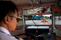 Bangkok. Chao Praya Express Boat driver. Bangkok, Inside public boat, ferry. Bangkok. Asia.  The Chao Phraya river makes a great way to get around, since many of the major tourist sites are easily accessible from the river. Chao Praya River Express operates a regular boat service up and down the river. Sort of a bus on the water. Fares are extremely cheap - you can get just about anywhere for 11 Baht to 25 Baht (0.34 USD to 0.76 USD) depending on the distance and the type of boat. There are piers next to many of the riverside hotels. Even if you aren't staying on the river, if you are staying close to the elevated train system, you can catch a train to the Taksin Bridge station. A River Express pier is on the river right below the station, and there is generally someone on duty at the pier to sell you a ticket and help plan your trip. The boats can be dangerously crowded during peak traffic times, so avoid rush hours.. Chao Phraya Pier Guide. 