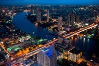 Bangkok. Panoramic viws and landcape of Bangkok from Sirocco rooftop. Thailand. Asia, Bangkok, capital, Centara Grand, Chao Praya River, City, cocktails, dome, Drinks, dusk, Lebua St. Sirocco rooftop bar at Lebua hotel, Bangkok, Thailand. The sense of 'having arrived' at one of Bangkok's most iconic restaurants begins with the ascent to the 63rd floor and the walk down the artistically lit staircase, with the city below and the soothing strains of the jazz band resonating through the warm breeze. Sirocco is the world's largest all open-air restaurant and "Sky Bar", located on the 64th floor of the State Tower in Bangkok, Thailand, which is the second tallest building in Thailand. The 150-capacity restaurant opened its doors in the winter of 2003. 
