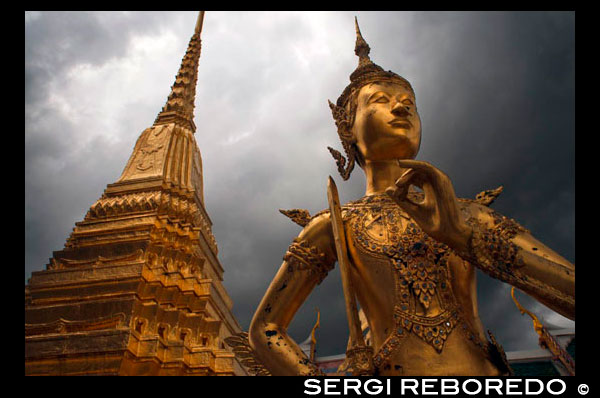 Grand Palace Wat Phra Kaeo Estatua Oro Apsonsi Bangkok Tailandia. Gran Palacio y el Templo del Buda de Esmeralda Wat Phra Kaeo. El Gran Palacio LBTR: Phra Borom Maha Ratcha Wang es un complejo de edificios en el centro de Bangkok, Tailandia. El palacio ha sido la residencia oficial de los Reyes de Siam (y más tarde Tailandia) desde 1782. El rey, su corte y su gobierno real se basaron en los terrenos del palacio hasta 1925. El actual monarca, el rey Bhumibol Adulyadej (Rama IX ), actualmente reside en Chitralada Palace, pero la Gran Palacio aún se utiliza para actos oficiales. Varias ceremonias reales y las funciones del Estado se llevan a cabo dentro de los muros del palacio cada año. El palacio es uno de los atractivos turísticos más populares en Tailandia. El Atrio o Khet Phra Racha Que Chan Na de la Grand Palace está situado al noroeste del palacio (el noreste siendo ocupado por el Templo del Buda Esmeralda). Entrando por la puerta principal Visetchaisri, el Templo del Buda Esmeralda se encuentra a la izquierda, con muchos edificios públicos ubicados a la derecha. El Templo del Buda de Esmeralda o Wat Phra Kaew formalmente conocido como Wat Phra Si Rattana Satsadaram, es una capilla real situada dentro de los muros del palacio. Refiere incorrectamente como un templo budista, es de hecho una capilla; que tiene todas las características de un templo a excepción de la zona de habitación para los monjes. Construido en 1783, el templo fue construido de acuerdo con la antigua tradición que se remonta a Sukotai, una capilla real dentro de los terrenos del palacio real en Sukhothai, y Wat Phra Sri Sanpetch en Ayutthaya. El famoso Buda de Esmeralda se mantiene dentro de los terrenos del templo.