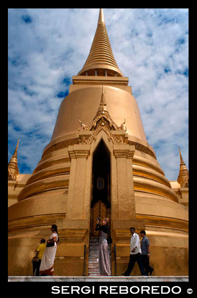 Stupa de oro, Templo del Buda de Esmeralda (Wat Phra Kaew) en el Gran Palacio de Bangkok, Tailandia, el sudeste de Asia, Asia. El Gran Palacio LBTR: Phra Borom Maha Ratcha Wang es un complejo de edificios en el centro de Bangkok, Tailandia. El palacio ha sido la residencia oficial de los Reyes de Siam (y más tarde Tailandia) desde 1782. El rey, su corte y su gobierno real se basaron en los terrenos del palacio hasta 1925. El actual monarca, el rey Bhumibol Adulyadej (Rama IX ), actualmente reside en Chitralada Palace, pero la Gran Palacio aún se utiliza para actos oficiales. Varias ceremonias reales y las funciones del Estado se llevan a cabo dentro de los muros del palacio cada año. El palacio es uno de los atractivos turísticos más populares en Tailandia. El Atrio o Khet Phra Racha Que Chan Na de la Grand Palace está situado al noroeste del palacio (el noreste siendo ocupado por el Templo del Buda Esmeralda). Entrando por la puerta principal Visetchaisri, el Templo del Buda Esmeralda se encuentra a la izquierda, con muchos edificios públicos ubicados a la derecha. El Templo del Buda de Esmeralda o Wat Phra Kaew formalmente conocido como Wat Phra Si Rattana Satsadaram, es una capilla real situada dentro de los muros del palacio. Refiere incorrectamente como un templo budista, es de hecho una capilla; que tiene todas las características de un templo a excepción de la zona de habitación para los monjes. Construido en 1783, el templo fue construido de acuerdo con la antigua tradición que se remonta a Sukotai, una capilla real dentro de los terrenos del palacio real en Sukhothai, y Wat Phra Sri Sanpetch en Ayutthaya. El famoso Buda de Esmeralda se mantiene dentro de los terrenos del templo.