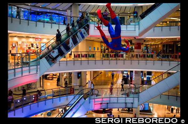 Centralworld mall. Bangkok. Thailand. A hanging Spider-Man figurine displayed at a Bangkok shopping-mall. To celebrate the launch of the movie The amazing Spider-Man 2 in Bangkok, a well-known shopping-mall displays a huge hanging Spider-Man figurine. The mall is Bangkok's largest with hundreds of shops. CentralWorld mega-shopping complex offers one of the most exciting shopping experiences in Bangkok. It has everything from brand name clothing boutiques, funky fashion, high-tech gadgets, bookshops and designer furniture to imported groceries, a lineup of banks, beauty salons, gourmet eateries and even an ice-skating rink. With so many tantalising options to explore, you could easily spend half a day here without realising it. It will come as no surprise to anyone who has experienced the incredible size of CentralWorld that this is, in fact, the largest mall in Thailand and among the largest in the world. We think it’s safe to say that if you are looking for a shopping fix in Bangkok this place will deliver. Occupying some 550,000 square metres of retail space and a total area size of 830,000 square metres – that is 30% larger than any other shopping centre in central Bangkok – CentralWorld has a range of offerings that encompass more than 500 stores, 100 restaurants and cafes, 15 cinemas, Kids' Zone and Learning Centre(Genius Planet Zone), two anchor department stores, as well as a trendy food court, an expansive supermarket and an outdoor square for large-scale events like Bangkok's official New Year countdown party. The location is slap-bang in the heart of the Chidlom 'battleground of the malls' with direct Skytrain (BTS) access and home to the two famous shrines, Erawan Shrine and Trimurti Shrine.