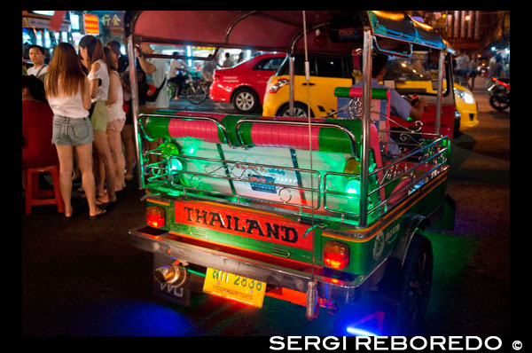Tuk tuk al carrer. Vegi avall de la carretera Thanon Yaowarat a la nit al cèntric barri de Chinatown de Bangkok, Tailàndia. Yaowarat i Phahurat és multicultural barri de Bangkok, situada a l'oest de Silom i sud-est de Rattanakosin. Yaowarat Road és la llar de la comunitat xinesa gran de Bangkok, mentre que els d'ètnia índia s'han congregat al voltant Phahurat Road. Durant el dia, Yaowarat no es veu molt diferent de qualsevol altra part de Bangkok, encara que el barri se sent com un gran mercat del carrer i hi ha algunes joies ocultes esperant a ser explorat. Però a la nit, els rètols de neó resplendents amb caràcters xinesos estan encesos i les multituds dels restaurants es deixen caure pels carrers, convertint la zona en una miniatura de Hong Kong (menys els gratacels). Phahurat és un lloc excel·lent per a la compra de teles, accessoris i objectes religiosos. Una visita a la zona no està completa sense comptar amb alguns dels seus menjars sorprenents que es venen per una absoluta ganga - com niu d'ocell o alguns curris indis. El barri xinès de Bangkok és una atracció turística popular i un refugi d'aliments per gourmands de nova generació que es reuneixen aquí després del capvespre per explorar la vibrant cuina a peu de carrer. A l'hora del dia, no és menys concorregut, com hordes de compradors descendeixen sobre aquesta franja d'1 km i adjacent Charoenkrung camí per obtenir valor d'un dia de primera necessitat, l'or del comerç, o pagar una visita a un dels temples xinesos. Ple de llocs de mercat, restaurants de carrer i una densa concentració de botigues d'or, el barri xinès és una experiència que no et perdis. L'energia que emana de les seves interminables files de fusta cases-botiga és pla contagiosa - que el mantindrà amb ganes de tornar per més. Organitzeu la vostra visita durant els grans festivals, com l'Any Nou Xinès, i veurà Bangkok Chinatown en el seu millor moment.