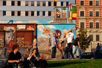 Germany, Berlin. A relaxing afternoon on the lawn of the East side gallery along the Spree. The East Side Gallery is an international memorial for freedom. It is a 1.3 km long section of the Berlin Wall located near the centre of Berlin on Mühlenstraße in Friedrichshain-Kreuzberg. The actual border at this point was the river Spree. The gallery is located on the so-called "hinterland mauer", which closed the border to East Berlin. The Gallery consists of 105 paintings by artists from all over the world, painted in 1990 on the east side of the Berlin Wall. The East Side Gallery was founded following the successful merger of the two German artists' associations VBK and BBK. The founding members were the speche of the Federal Association of Artists BBK Bodo Sperling, Barbara Greul Aschanta, Jörg Kubitzki and David Monti.