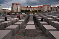 Berlin Memorial for the Murdered Jews of Europe. Holocaust memorial. The Memorial to the Murdered Jews of Europe, one of the most evocative and controversial monuments to the Holocaust, was designed by the American architect Peter Eisenmann. The Holocaust Memorial is located in the center of Berlin, laid out on a 4.7 acre site between Potsdamer Platz and the Brandenburg Gate. The centerpiece of the Holocaust memorial is the “Field of Stelae”, covered with more than 2,500 geometrically arranged concrete pillars.  You can enter and walk through the unevenly sloping field from all four sides. The strong columns, all slightly different in size, evoke a disorienting, wave-like feeling that you can only experience when you make your way through this gray forest of concrete.
