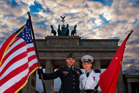 Berlin. Germany. Actors dressed as American and Soviet soldiers pose for photos with tourists in front of the Brandenburg Gate in Berlin, one of the Cold War's most iconic landmarks. The Brandenburg Gate is the trademark of Berlin. The main entrance to the city, surrounded by the wall for thirty years, was known throughout the world as a symbol for the division of the city and for the division of the world into two power blocs. Today's international visitors to Pariser Platz come to re-experience this first gateway to the city, and to enjoy the long-denied freedom to walk through this magnificent work of art and look at it up close. 