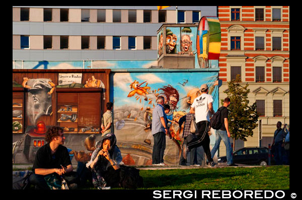 Alemania, Berlín . Una tarde de relax en el césped de la East Side Gallery , junto al río Spree. La East Side Gallery es un monumento internacional por la libertad. Se trata de una sección de 1,3 kilometros de largo del muro de Berlín, situado cerca del centro de Berlín, en Mühlenstraße en Friedrichshain . La frontera actual en este punto era el río Spree . La galería está ubicada en el llamado " mauer hinterland " , que cerró la frontera a Berlín Oriental . La Galería consta de 105 pinturas de artistas de todo el mundo , pintado en 1990 en el lado este del Muro de Berlín . La East Side Gallery fue fundada tras la fusión exitosa de asociaciones VBK los dos artistas alemanes y BBK . Los miembros fundadores fueron la speche de la Asociación Federal de Artistas BBK Bodo Sperling , Barbara Greul Aschanta , Jörg Kubitzki y David Monti. Es posiblemente la galería al aire libre más grande y de mayor duración en el mundo. Pinturas de Jürgen Grosse alias INDIANO , Dimitri Vrubel , Siegfrid Santoni , Bodo Sperling, Kasra Alavi , Kani Alavi , Jim Avignon , Thierry Noir, Ingeborg Blumenthal , Ignasi Blanch i Gisbert, Kim Prisu , Hervé Morlay VR y otros han seguido . Las pinturas en el documento de East Side Gallery un momento de cambio y expresar la euforia y grandes esperanzas de un futuro mejor , más libre para todos los pueblos del mundo . En julio de 2006 , para facilitar el acceso al río Spree de O2 World , una sección de 40 metros se trasladó un poco al oeste , en paralelo a la posición original Una sección de 23 metros está programado para ser eliminado el 1 de marzo de 2013, para dar paso a apartamentos de lujo . Ninguno de los artistas cuyas obras serán destruidas fueron informados de estos planes. El trabajo de demolición en realidad comenzó el 1 de marzo de 2013. Según alemana de noticias FOCUS, las autoridades no tenían conocimiento del inicio de la demolición. Debido a la participación de los manifestantes , la demolición se pospuso hasta por lo menos el 18 marzo de 2013.