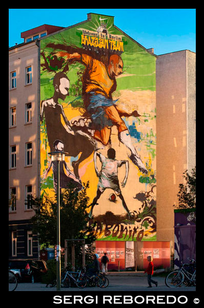 Graffiti en una casa prop del Parc del Mur , Berlín en la nit la llum d'Alemanya. Benvingut a Belin , l'equip brasiler . Joga Bonito. Mauerpark és un parc lineal pública al districte de Prenzlauer Berg de Berlín . El nom es tradueix com " parc de la paret ", en referència a la seva condició d'ex part del mur de Berlín i la seva franja de la mort . El parc està situat a la frontera de Prenzlauer Berg i el districte Gesundbrunnen l'antic Berlín Occidental . En els segles 19 i 20 , la zona de Parc del Mur va servir de seu de l'antic Nordbahnhof ( " estació del Nord" ) , el terme meridional de la prussiana Ferrocarril del Nord va obrir les seves portes el 1877 /78, que connecta Berlín amb la ciutat de Stralsund i el mar Bàltic . Poc després que va perdre la seva funció com a estació de passatgers a la propera Stettiner Bahnhof i va romandre en ús com un pati de càrrega . El 1950 , el Stettiner Bahnhof va prendre el nom Nordbahnhof causa del seu paper en el sistema de transport públic de Berlín , i l'Antic Nordbahnhof es coneixia com Güterbahnhof Eberswalder Straße . Finalment es va tancar després de la construcció del Mur de Berlín el 1961 . Quan es mira des de dalt , encara es poden veure restes de les vies del ferrocarril que cap a l'antiga estació del Ringbahn