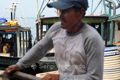 A fisherman on a boat in the port of Semporna. Borneo. A khaki patrol boats also at odds among all white. fter the second dive, which has already lost count of the species you've seen, the boat goes to Mabul, where does the third. This immersion is almost always worse than Sipadan because the pressure on the ecosystem of all people housed is very strong and the visibility is always smaller. I recommend it for diving fans who are able to do 5 or 6 dives a day, because the platform has all the advantages of being on a dive boat but none of its drawbacks, even when the wind is strong, it wobbles a bit, but never like a boat. With 5 floors that can accommodate nearly 100 people, just dive suit and put you down in an elevator. Some even intrepid divers throw from the platform into the sea. At the very heart of the platform, placed on 6 huge piles resting on the bottom at 15 meters depth, is enormous variety of wildlife, including fish that did not know, and it seems "impossible", frogfish, Walking with hands instead of fins and looks weird. The platform is near Mabul and other dives are made between Mabul, Sipadan and Kapalai. Kapalai is an island invisible 2 times a day because it is actually a sandbar that disappears at high tide, and she just overlook the huts built on stilts.