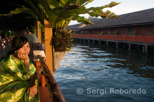 Interior Gateway Hotel Dragon Inn in Semporna. Eastern Sabah. A girl looking at one of the canals. Sleeping on the water can be an unforgettable experience, especially if done in one of these accommodations, designed to meet all the needs and whims ... Built on the sea Semporna, Dragon Inn Resort offers floating thatched roofs. The structural design of the hotel makes the guests feel like they are in a traditional village on the Bajau water.