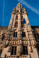 Hôtel de Ville. The town hall, which occupies the southwest facade is the only medieval building left standing today and was built between 1402 and 1455 probably by Jean Bornoy. Its tower, asymmetrical with respect to the building, 96 feet high, is of Gothic style and was designed by Jean van Ruysbroeck in 1449. An urban legend that the architect, to verify the alleged error that the tower will be located in the center, got into it and he jumped, although in truth both parties were not built at the same time. Atop the tower is a high bronze statue of five meters of the archangel Michael, patron saint of Brussels, slaying a dragon or devil. The left part of the council consists of twelve arches, including the bell tower, representing the twelve stages wet alchemy. Instead, the right side only has seven arches, counting the bell, symbolizing the new alchemy dry in seven stages. The facade is decorated with numerous statues representing nobles, saints, and allegorical figures.