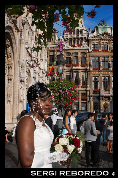 On Saturday morning weddings are held in the Hôtel de Ville (city hall). The town hall, which occupies the southwest facade is the only medieval building left standing today and was built between 1402 and 1455 probably by Jean Bornoy. Its tower, asymmetrical with respect to the building, 96 feet high, is of Gothic style and was designed by Jean van Ruysbroeck in 1449. An urban legend that the architect, to verify the alleged error that the tower will be located in the center, got into it and he jumped, although in truth both parties were not built at the same time. Atop the tower is a high bronze statue of five meters of the archangel Michael, patron saint of Brussels, slaying a dragon or devil. The left part of the council consists of twelve arches, including the bell tower, representing the twelve stages wet alchemy. Instead, the right side only has seven arches, counting the bell, symbolizing the new alchemy dry in seven stages. The facade is decorated with numerous statues representing nobles. WEDDING IN THE CITY OF BRUSSELS. BELGIAN WEDDING.