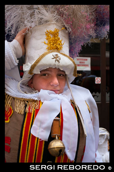 A child dressed in the typical costume of Binche. The Belgian festival Binche with their traditional costumes: Eastern princes, sailors and harlequins. An amazing procession through the cobbled streets of the city to the beat of drums and artists with their wax masks and ostrich feathers. Quite an experience. HUGE HAT AND RATTLESNAKE.