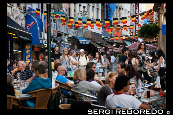 In the center of Brussels abound terraces and restaurants offering cuisine from around the continent. Crowded street BARS AND RESTAURANTS IN BELGIAN FLAG