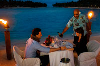 Aitutaki. Cook Island. Polynesia. South Pacific Ocean. A couple enjoys a romantic dinner by the beach in Aitutaki Lagoon Resort & Spa Hotel. As the only resort directly on the world's most beautiful lagoon, The Aitutaki Lagoon Resort & Spa is truly blessed. This exclusive all-bungalow resort is one-of-a-kind in many other respects also. It is the only private island resort in the Cook Islands. The Aitutaki Lagoon Resort & Spa is a luxury resort destination on one of the most famous lagoons in the world. This Cook Islands paradise provides a naturally romantic setting, and the resort is a popular accommodation option, especially with honeymoon couples, those wishing to get married in Aitutaki, and anyone looking for an idyllic paradise island getaway. Guests may choose between beachfront and garden bungalows or opt for an overwater bungalow - the only destination in Cook Islands to offer overwater accommodation. The resort offers top hotel amenities, fine cuisine and a range of recreational activities: 7 Overwater bungalows - Cook Islands only overwater accommodation. 14 Beachfront and 16 Garden bungalows. Air-conditioning, TV/DVD/CD, king or queen beds, mini-bar etc. Relax at The Flying Boat Beach Bar & Grill. The Bounty Restaurant offers fine dining experience. Theme nights and Aitutaki entertainment. Complimentary activities include snorkeling, kayaking, biking, beach volleyball, guided hikes and cultural activities. Pay-for activities include deep sea fishing and scuba diving. Romantic wedding packages. Spa Facility at the SpaPolynesia, with extensive health and beauty treatments available. 