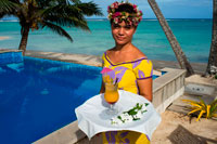 Rarotonga Island. Cook Island. Polynesia. South Pacific Ocean. A waitress serves delicious next to the poolside at the luxurious Little Polynesian Resort in Rarotonga. Nestled on the southern tip of Rarotonga, Little Polynesian Resort is a sophisticated playground for grown-ups. Here, serenity is certain, seclusion is guaranteed, and romance is everywhere. This is a Resort of unpretentious luxury where idyllic beaches beckon. The Beachfront Ares offer an uninterrupted vista of the azure lagoon while the view of tropical gardens from the garden thatched Ares is just as dazzling. Welcoming guests over the age of 15 years only, the primary clientele of the Resort are honeymooners and couples. Set on an unspoilt beach, the Resorts dwellings ooze Polynesian charm and luxury. Spend your days roaming the beaches and sipping fresh-fruit cocktails by the pool. Traditional architecture complements the island’s natural beauty, and the bungalows are designed with every modern luxury, from gazebos with daybeds to outdoor showers. Experience the epitome of Polynesian luxury in our well-appointed beach and garden accommodations. The romance of traditional Polynesian architecture meets the creature comforts of the West in our modern interpretations of the local dwellings, or Are as they are known. Rendered in a minimalist palette of ivory and local woods, the spare elegance of our rooms takes the romance quotient up a notch. Traditional accents such as Wild Hibiscus, Mangaian (coconut) sinnet weaving on beams as well as a thatched roof with natural pandanus add to the ambience of our South Seas paradise. 