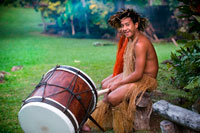 Rarotonga Island. Cook Island. Polynesia. South Pacific Ocean. Highland Paradise Cultural Village. Show in traditional Polynesian dress and drums.  Sometimes known as “the lost village” Highland Paradise is a cultural feast of Cook Islands entertainment and spiritual experiences. Wednesday and Friday sunset cultural nights and daily guided tours. AUTHENTIC AND AWARD WINNING! Weekday Guided tours of authentic historical sites in this mountain village refuge that lay forgotten for 150 years include re-enactments, interactive live days, restored maraes and faithfully rebuilt traditional buildings all recreating the ambience and spirituality of this sacred place where our ancestors lived, loved, fought and died. You will learn of our proud and sometimes, sad and sordid history. Amongst 25 developed acres of magnificent gardens and views you will experience drumming, singing, dancing, weaving, carving, medicine making, story telling and umu feasting just as they were more than 600 years ago on this very spot! The multi award winning, Wednesday and Friday sunset cultural nights, include hosted roundtrip transport, expert guides, village cultural immersion experiences, marae visit, a tapu lifting, warrior welcome, cocktail, underground oven (umu) feasting like you have never experienced and spectacular stage show telling the story of our ancient heritage through singing, dancing and drumming. 