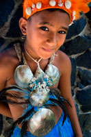 Rarotonga Island. Cook Island. Polynesia. A boy dressed as a dancer of the Cook Island around the Punanga Nui Markets. To the despair of many educated Cook Islanders the expression "culture" in the popular mind equates to traditional festivals, singing and dancing. There is some justification for this since the art of dance is taken very seriously in the Cooks. Each island has its own special dances and these are practised assiduously from early childhood. There are numerous competitions throughout the year on each island – Events – and these are hotly contested. The highly rhythmic drumming on the paté and the wild and sensuous movements of both men and women virtually guarantee that Cook Islands teams win all the major Pacific dance festivals.The Hawaiian hula and the Tahitian tamuré are probably better known because those islands have had wider publicity for the last 100 years but the Cook Islands hura is far more sensual and fierce. Every major hotel prides itself on the performance it puts on at least once a week on Island Night when guests, selected by the dancers, are led onto the floor to show what they can do. Cook Islands dancing. It there is one outstanding ability which appears to be shared by all Cook Islanders it is music and song. Close harmony singing is highly developed in church music and the power and emotional impact of chants and hymns at weddings and funerals is well known to visitors who attend. The range and talent of popular singing can be seen at the numerous festivals throughout the year (see Events). 