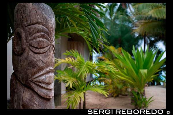 Rarotonga Island. Cook Island. Polynesia. South Pacific Ocean. Totem located outside the luxurious Little Polynesian Resort in Rarotonga. The Little Polynesian is surrounded with the kind of natural beauty that the South Pacific is renowned for. In 2005, the Little Polynesian underwent extensive renovations to unveil what can only be described as a literal re-creation to achieve once again a new level of service and amenities. Our magnificently built Ares (bungalows) have been designed with intricate attention to detail. Every unit uses traditional Cook Islands architecture combined with understated yet richly elegant décor. Little Polynesian a small luxury hideaway in Titikaveka on the island of Rarotonga overlooks a gorgeous white sand swimming beach with excellent snorkeling offshore and there are free kayaks to explore the turquoise lagoon. The no child policy ensures absolute privacy - making it the ideal place for honeymoons and romantic breaks. All rooms are non-smoking. The Little Polynesian offers all the amenities one would expect from the Cook Islands' most upscale boutique resort. The Luxury Beach Ares promise aimless days of looking out to the lagoon's turquoise waters and waking up to the gentle sound of waves, while the scent of tropical flowers fills the air around our garden villas. Traditional accents in the bungalows including Wild Hibiscus, Mangaian (coconut) sinnet weaving on beams as well as a thatched roof with natural Pandanus add to the ambience of our South Seas paradise. The scent of tropical flowers fills the air around the fourGarden Pia Tiare (Garden Villas) - providing a special experience that's close to nature. Like the Beach Ares, each is equipped with a spacious king size bed, out door shower and spa tub and bar fridge. Clear blue skies, a turquoise lagoon, calm waters and a temperate climate make it ideal for a number of water-based activities including swimming, snorkeling, diving, sport fishing, game fishing, and kayaking. Other activities include hiking, pony trekking, cultural tours, bird-watching tours, scenic flights, golf, tennis, squash and lawn bowls. What could be more romantic than saying “"I do" at a beach or garden wedding at the Little Polynesian?.  