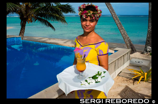 Rarotonga Island. Cook Island. Polynesia. South Pacific Ocean. A waitress serves delicious next to the poolside at the luxurious Little Polynesian Resort in Rarotonga. Nestled on the southern tip of Rarotonga, Little Polynesian Resort is a sophisticated playground for grown-ups. Here, serenity is certain, seclusion is guaranteed, and romance is everywhere. This is a Resort of unpretentious luxury where idyllic beaches beckon. The Beachfront Ares offer an uninterrupted vista of the azure lagoon while the view of tropical gardens from the garden thatched Ares is just as dazzling. Welcoming guests over the age of 15 years only, the primary clientele of the Resort are honeymooners and couples. Set on an unspoilt beach, the Resorts dwellings ooze Polynesian charm and luxury. Spend your days roaming the beaches and sipping fresh-fruit cocktails by the pool. Traditional architecture complements the island’s natural beauty, and the bungalows are designed with every modern luxury, from gazebos with daybeds to outdoor showers. Experience the epitome of Polynesian luxury in our well-appointed beach and garden accommodations. The romance of traditional Polynesian architecture meets the creature comforts of the West in our modern interpretations of the local dwellings, or Are as they are known. Rendered in a minimalist palette of ivory and local woods, the spare elegance of our rooms takes the romance quotient up a notch. Traditional accents such as Wild Hibiscus, Mangaian (coconut) sinnet weaving on beams as well as a thatched roof with natural pandanus add to the ambience of our South Seas paradise. The Little Polynesian offers all the amenities one would expect from the Cook Islands’ most upscale boutique resort. Our overbeach Ares (bungalows) promise aimless days of looking out to the lagoon’s turquoise waters and waking up to the gentle sound of waves, while the scent of tropical flowers fills the air around our Pia Tiare (garden units). Whichever you choose, we guarantee you will be immersed in nature at the Little Polynesian.