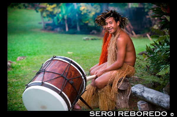 Rarotonga Island. Cook Island. Polynesia. South Pacific Ocean. Highland Paradise Cultural Village. Show in traditional Polynesian dress and drums.  Sometimes known as “the lost village” Highland Paradise is a cultural feast of Cook Islands entertainment and spiritual experiences. Wednesday and Friday sunset cultural nights and daily guided tours. AUTHENTIC AND AWARD WINNING! Weekday Guided tours of authentic historical sites in this mountain village refuge that lay forgotten for 150 years include re-enactments, interactive live days, restored maraes and faithfully rebuilt traditional buildings all recreating the ambience and spirituality of this sacred place where our ancestors lived, loved, fought and died. You will learn of our proud and sometimes, sad and sordid history. Amongst 25 developed acres of magnificent gardens and views you will experience drumming, singing, dancing, weaving, carving, medicine making, story telling and umu feasting just as they were more than 600 years ago on this very spot! The multi award winning, Wednesday and Friday sunset cultural nights, include hosted roundtrip transport, expert guides, village cultural immersion experiences, marae visit, a tapu lifting, warrior welcome, cocktail, underground oven (umu) feasting like you have never experienced and spectacular stage show telling the story of our ancient heritage through singing, dancing and drumming. The dancers, musicians, chefs, barmen and guides are all descendants of Ariki (High Chief) Tinomana and are proud to be part of the extended family which brings this mountain village back to life and keeps it alive.