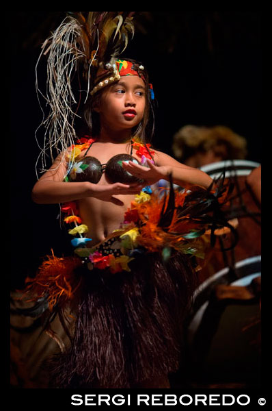 Rarotonga Island. Cook Island. Polynesia. South Pacific Ocean. Highland Paradise Cultural Village. A girl performs traditional dances of the Cook Island during the Highland Paradise Cultural Village show. Our Wednesday and Friday sunset cultural nights include hosted roundtrip transport, guides, village experience visit, tapu lifting, warrior welcome, a cocktail, a traditional Umu (underground oven) feast and a spectacular stage show telling the story of our ancient heritage through singing, dancing and drumming. Our dancers, musicians, chefs, barmen and guides are all descendants of Ariki (High Chief) Tinomana and are proud to be part of the extended family which brings this mountain village back to life – for you! Puaikura villagers are involved in all aspects of the Highland Paradise experience, as guides, dancers, drummers, warriors, weavers, carvers, cooks, medicinal experts and many more. Most are understudied by village children - a legacy for the future. Guests are transported by coach from their accommodation in the late afternoon to Highland Paradise where an evening of utterly unique and truly authentic cultural entertainment and feasting awaits!
