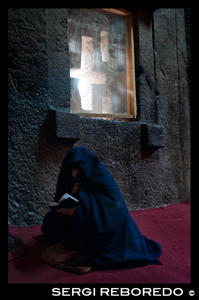 Lalibela. A woman prays inside Bet Medhane Alem church. To admire the churches of Lalibela must not look up, but towards the feet. The largest church is Bet Medhane Alem, the largest of all, with 33 meters long by 25 meters wide and a lavish decor reminiscent of Greek temples. The Emmanuel Beth, a few hundred meters east of the previous one, is one of the most beautiful and carved all that surely served as a royal chapel. Over 700 years ago, an Ethiopian king decided to make their city the "Jerusalem" of the Orthodox Christian world. But instead of lifting large temples in the classical manner, came excavate the rock to enemies who harassed his kingdom not easily locate. The result was one of the wonders of the ancient world, a set of eleven churches divided into two groups, plus a separate twelfth of these, which were deconstructing a chisel blow, emptying the rock until an internal volume equal to that which would achieved in a classical temple, with a Greek cross, columns, capitals, arbours and altars, everything is just one piece. The place is called Lalibela, is in an inaccessible corner of northern Ethiopia, near the border with Eritrea, in the middle of arid mountains, poor and naked verdean just during the rainy season. And is one of the places I have impacted my life traveler, one of those places that I would recommend to anyone visiting before getting old. 