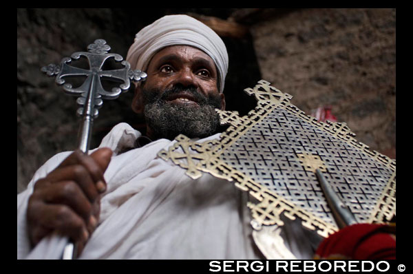 The priest of the church of Nakuto Lab, outside Lalibela shows his cross. It is unknown why were excavated soil or built, high construction of the building difficulty and increased costs. Shuffle several theories, one of the most accepted is that were raised during the height of Christian pilgrimage, with Jerusalem as the center axis or principal thereof, along the way, pilgrims faced many dangers and churches were exposed to vandalism and looting, perhaps this is the reason why the king decided to bury Lalibela churches, protecting them from possible looting. Little is also known of the construction process, plans have not been found, do not know the name of the architects, the duration of the work, the methodology employed, the use of scaffolding or ramps ..., what is known is the hard work it took to build the churches, where the "workers" performed work like excavation of a mine is involved. The architecture of the Lalibela has eleven churches carved into the stone floor of reddish volcanic. First he built a moat around the stony mass or space that would occupy the future church, this pit would work from the outside to the builders and today provides access to temples by stairs or ramps. Its symbolism is the separation of the sacred from the profane space.