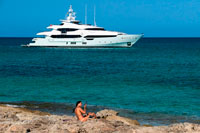 Formentera. Attractive woman combing. Es Pujols beach, Formentera. Luxury yacht in turquoise water in Es Pujols beach Formentera mediterranean sea Balearic Islands