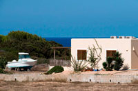 Formentera. Typical white house of Formentera. Es Calo de San Agusti beach, Formentera Island, Mediterranean sea, Balearic Islands, Spain. Es Calo de San Agusti with boat in Formentera island 