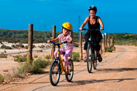 Formentera. Mother and daughter are riding in a bike. Pudent Lake. Formentera. Balearic Islands, Spain, Europe. Bicycle route.