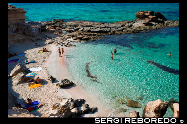 Es caló des Mort, Migjorn beach, Formentera, Balears Islands, Spain. Holiday makers, tourists, Es caló des Mort, beach, Formentera, Pityuses, Balearic Islands, Spain, Europe.  Situated on the southern coast of Formentera, and at 6 km Playa Migjorn is by far the longest beach on the island. One of the most popular of all the beaches, Playa Migjorn boasts fine white sand (some stretches partly scattered with rocks), clear blue sea, little fun beach bars and quality restaurants. What more could you possibly want? This is also another paradise for nudists, and for snorkelers the off-shore rocks hide a wealth of marine life. A real Robinson Crusoe beach!