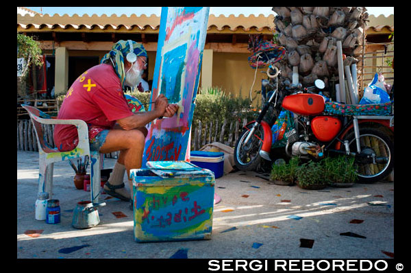 Hippy craftsman and painter in the Hippy Market, Pilar de la Mola, Formentera, Balearic Islands, Spain, Europe Spain; Formentera; island; crafsman; hippy; market; Pilar de la Mola; mola; tourists; souvenirs; painter; paint; motorbike; motorcicle; old; elder; elderly; color; colorful; pour; poeple; pace and loce; craft; fair; balearic; eco; fashion; cheap; cheaper; ecological; alternative; sell; buy; Baleares; atrraction; destination; Europe; European; holiday; travel; islands; mediterranean; photos; place; spanish; sun; tourism; touristic; vacation; view; Balearics; beautiful; beauty; paradise; fun; happy; coastal; paradisiac; popular