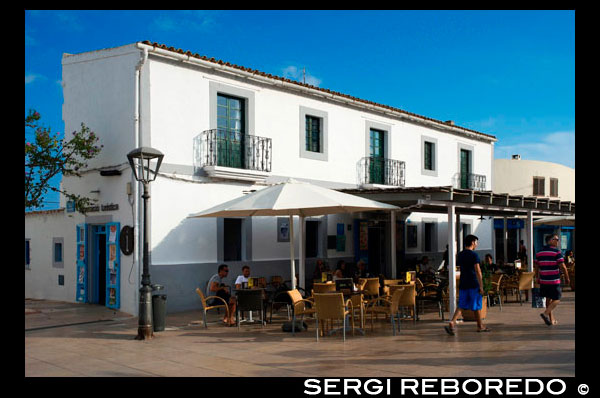 Tourists, Bars and restaurants in main square of Sant Francesc Xavier, San Francisco Javier, Formentera, Pityuses, Balearic Islands, Spain, Europe.   Spain; Formentera; island; balearic; Sant Francesc; Xavier; San Francisco; Francisco; Javier; main; square; central; typical; white; houses; house; bar; bars; rentaurant; restaurants; tourists; nice; town hall; day; daylight; daytime; during; europe; european; exterior; exteriors; formentera; holiday; holidays; island; islands; javier; journey; outdoor; photo; photos; pityuses; place; places; san; sant; shot; shots; small; south; southern; spain; spanish; square; squares; tourism; tourists; town; towns; travel; travelling; travels; trip; trips; vacation; vacations; village; villages; Baleares; atrraction; destination; Europe; European; holiday; travel; islands; mediterranean; photos; place; spanish; sun; tourism; touristic; vacation; view; Balearics; beautiful; beauty; paradise; fun; happy; coastal; paradisiac; popular
