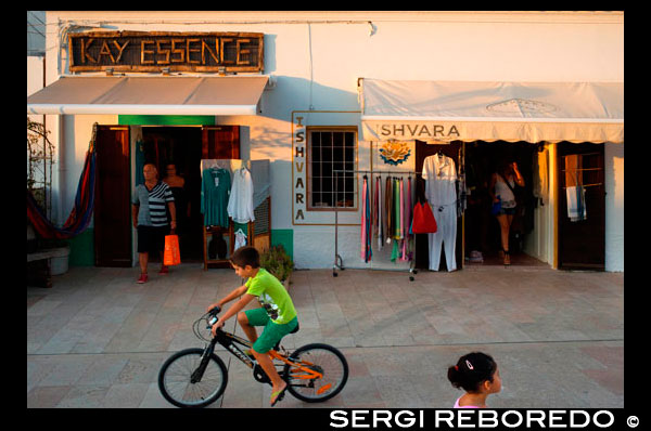 Tourists, Shops in main square of Sant Francesc Xavier, San Francisco Javier, Formentera, Pityuses, Balearic Islands, Spain, Europe.   Spain; Formentera; island; balearic; Sant Francesc; Xavier; San Francisco; Francisco; Javier; main; square; central; typical; white; houses; house; kid; bike; bicycle; shops; shop; kay; essence; fashion; store; tourists; nice; town hall; day; daylight; daytime; during; europe; european; exterior; exteriors; formentera; holiday; holidays; island; islands; javier; journey; outdoor; photo; photos; pityuses; place; places; san; sant; shot; shots; small; south; southern; spain; spanish; square; squares; tourism; tourists; town; towns; travel; travelling; travels; trip; trips; vacation; vacations; village; villages; Baleares; atrraction; destination; Europe; European; holiday; travel; islands; mediterranean; photos; place; spanish; sun; tourism; touristic; vacation; view; Balearics; beautiful; beauty; paradise; fun; happy; coastal; paradisiac; popular