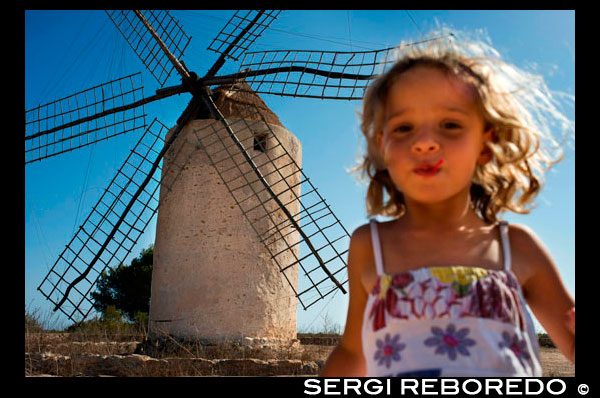 Funy girl in the windmill, Formentera, Balearic Islands, Spain. Old Windmill in el Pilar de la Mola on the island Formentera, Balearic Islands, Spain  Spain; Formentera; island; old; windmill; Pilar de la Mola; Mola; spanish; balearic; Baleares; atrraction; destination; Europe; European; holiday; travel; islands; mediterranean; photos; place; spanish; acient; architecture; countryside; destinations; nice; girl; child; travel; with; children; active; run; running; ecology; electricity; blonde; smile; energy; europe; european; exteriors; fields; formentera; historic; historical; horizontal; mill; mola; nobody; old windmill; outdoors; outside; power; production; renewable; rotates; rotating; rural; sightseeing; spain; spanish; sunshine; the balearic islands; tourism; tourists; traditional; travel; trees; trips; typical; wind; windmills; sun; tourism; touristic; vacation; view; Balearics; beautiful; beauty; paradise; fun; happy; coastal; paradisiac; popular