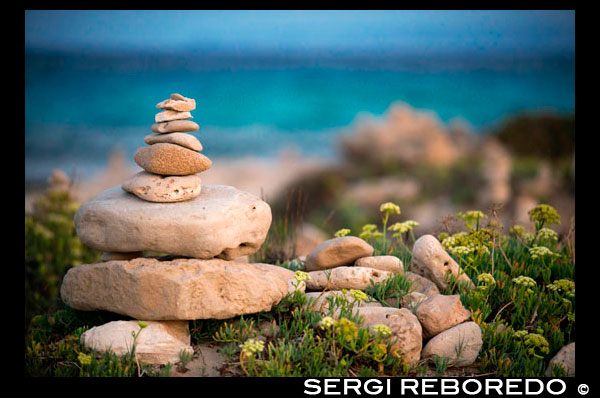 Ses Illetes Beach, Balearic Islands, Formentera, Spain. Backlights in the sunset with stones with different shapes. "The Flood" ("La Riada"), a unique space built with stones by the German Johannes Schultz. Spain; Formentera; island; Ses Illetes; beach; es pas; pas; illetes; sunset; stones; stone; backlight; zen; balance; creative; art; artist; relax; shape; shapes; coastline; marine; scene; outdors; sand; summer; balearic; nice; sea; boats; pretty; sunset; couple; walk; walking; sand; beauty; calo; beach; beautiful; beauty; blue; coast; people; man; woman; romantic; europe; holiday; idyllic; isla; island; islands; islet; landmark; landscape; mediterranean; nature; ocean; outdoor; paradise; places; rock; rocky; san; scenic; sea; seascape; shallow; shore; sky; spain; stones; holiday; horizon; islands; length; look; med; mediterranean europe; platge; platja; playa; rear; rocks; rocky; rough; sand; sandy; sea; single; slim; spain; spanish; stand; summer; tourism; travel; vacation; view; watch; wave; sun; sunny; touristic; transparent; travel; turquoise; vacation; water; waves; white; balearic; Baleares; atrraction; destination; Europe; European; holiday; travel; islands; mediterranean; photos; place; spanish; sun; tourism; touristic; vacation; view; Balearics; beautiful; beauty; paradise; fun; happy; coastal; paradisiac; popular