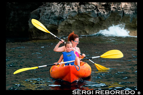 Mother and daughter doing kayaking on Cala Sahona, Formentera, Balearics Islands, Spain. Barbaria Cape. Spain; Formentera; kayak; kayaking; tradictional; beach; sea; Cala Sahona; Sahona; inlet; beautiful; mother; travel; with; child; children; kid; kids; woman; smile; people; girl; blue; clear; coast; coastline; crystalline; active; tourism; funny; happy; els; fishing; formentera; holiday; ibiza; idyllic; island; islands; landmark; landscape; mediterranean; nature; ocean; outdoor; paradise; pier; places; port; pujols; rail; railway; rock; scenic; sea; seascape; spain; stranded; summer; sunny; touristic; traditional; transparent; travel; turquoise; typical; vacation; water; white; wooden; island; balearic; Baleares; atrraction; destination; Europe; European; holiday; travel; islands; mediterranean; photos; place; spanish; sun; tourism; touristic; vacation; view; Balearics; beautiful; beauty; paradise; fun; happy; coastal; paradisiac; popular
