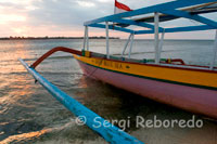 A boat rests on the sandy beach in the west of the island, near the pier Bounty Resort. Gili Meno.