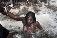 A woman bathing in one of the pools of Saut d'Eau to connect with Iwa. There are numerous diversifications (nanchons in Creole) from Iwas, which is invoked in a different order according to the ritual. The Iwa cited most frequently are those of the Rada rite, also known as sweet and good spirits. Almost all of the ceremonies consist of invocations to the Rada. At other times very specific to invoking the Petro rite, the Iwa hot, bitter or angry that you use to practice black magic. The Gede Iwa are associated with death and the passage to another world. There are also African Iwa as Ibo, Senegal and Kongo.
