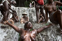 One of the festival attendees Saut d'eau voodoo goes into a trance. Voodoo Festival Saut d'Eau is celebrated every year on July 16 to coincide with the day on which in 1847 appeared a vision of the Virgin Mary. Thousands of devotees coming from all parts of Haiti are bathed in this water for purified or pra lose the Grand Master that their dreams become reality. Voodoo is the main religion of Haiti. The followers need to be possessed by a spirit Iwa to communicate with Grand Met, since this is abut far from the physical plane. In the photograph reads one of the assistants without clothes. Old clothes are often throwing the water and then, after purified, dressed in new clothes. The Vodun or Voodoo is a theist and magical form of animism that developed among the tribes of West Africa before the historic period in the territories of what was the Kingdom of Dahomey (now Benin). The cultural area of the villages Fon, Gun, Mina and Ewe share common metaphysical conceptions, centered around the idea of a dual cosmological principle of divine order. On the one hand we find God the Creator (whose name can vary, but they define as Mawu) and secondly a number of gods or spirits actors, sons of the Creator. Creator God would thus cosmogonic principle, isolated from worldly affairs and Voduns gods or spirits are the actors who rule over earthly matters.
