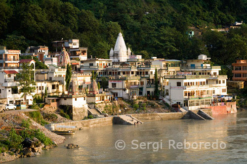 INDIA CROSSING THE RIVER GANGES Rishikesh also spelled Hrishikesh; Rushikesh; or Hrushikesh; is a city and a municipal board in Dehradun district in the Indian state of Uttarakhand.It is surrounded by two other districts namely Tehri Garhwal and Pauri Garhwal. It is located in the foothills of the Himalaya in northern India and attracts thousands of pilgrims and tourists each year; from within India; as well as from other countries. Rishikesh is a vegetarian city by law; as well as an alcohol-free city. Rishikesh has also banned use of plastics bags by shopkeepers and vendors. Rishikesh; sometimes nicknamed "the world capital of Yoga"; has numerous yoga centres that also attract tourists. It is believed that meditation in Rishikesh brings one closer to attainment of moksha; as does a dip in the holy river that flows through it. Rishikesh is world famous for Rafting and Adventure. Rafting season starts from the month of March and ends in July. Rishikesh is also home to the 120-year old Kailas Ashram Brahmavidyapeetham; an institution dedicated to preserve and promote the traditional Vedantic Studies. Prominent personalities such as Swami Vivekananda; Swami Rama Tirtha and Swami Shivananda have studied in this institution. In February 1968; The Beatles visited the now-closed Maharishi Mahesh Yogi's ashram in Rishikesh.[6] John Lennon recorded a song titled; 'The Happy Rishikesh Song'.[7][8] The Beatles composed nearly 48 songs during their time at the Maharishi's ashram; many of which appear on the White Album. Several other artists visited the site to contemplate and meditate.
